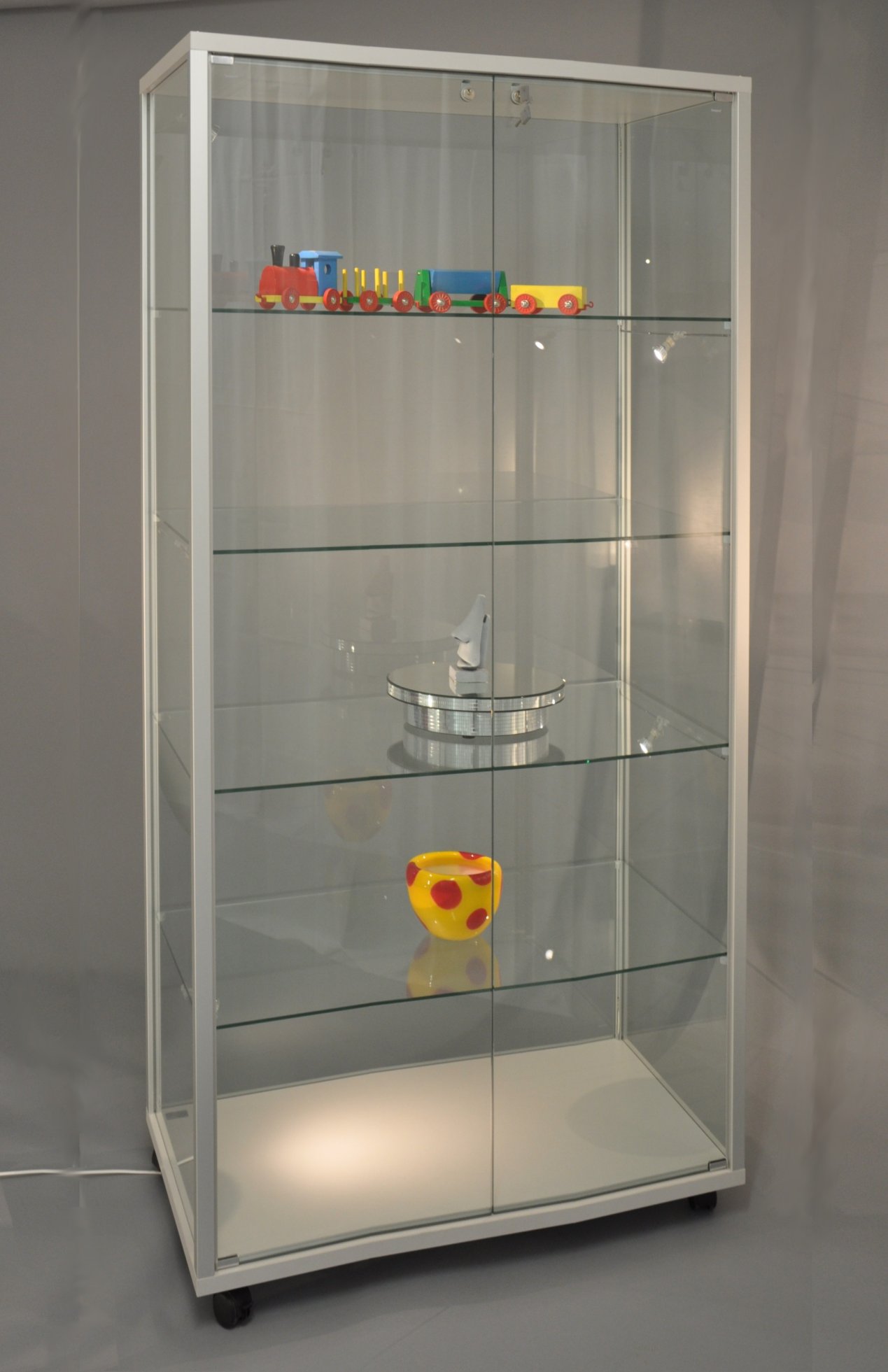 staubdichte Glasvitrine 79 x 53 x 183 cm auf Laufrollen mit abschließbaren Drehflügeltüren